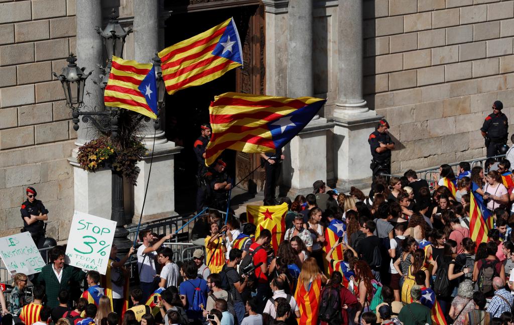 Protestors carrying Catalan separatist flags gather outside the Generalitat Palace, the regional government headquarters, in Bar