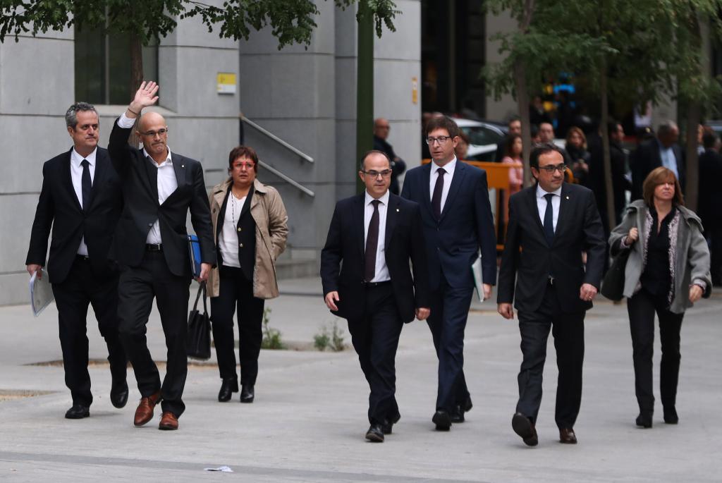 Dismissed Catalan Foreign Affairs chief Raul Romeva waves as he arrives to Spain's High Court after being summoned to testify on