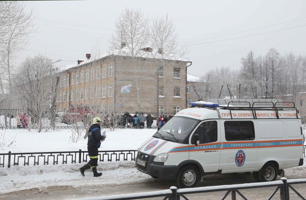 A vehicle of the Russian Emergencies Ministry is parked near a local school after reportedly several unidentified people wearing