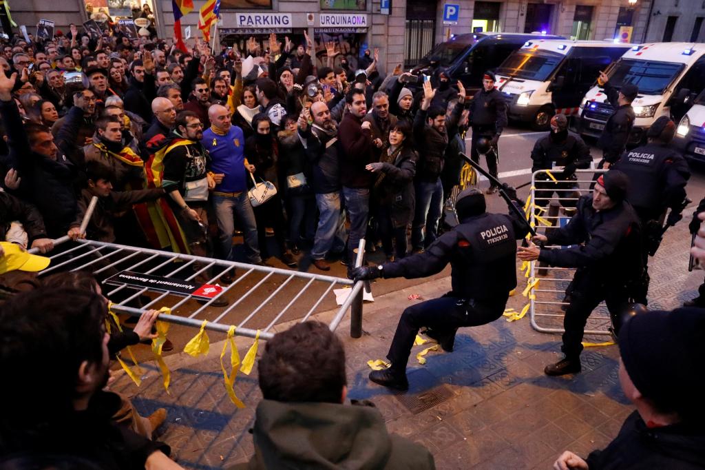 Catalan pro-independence demonstrators clash with Mossos d'Esquadra officers during a protest against King Felipe VI's official 