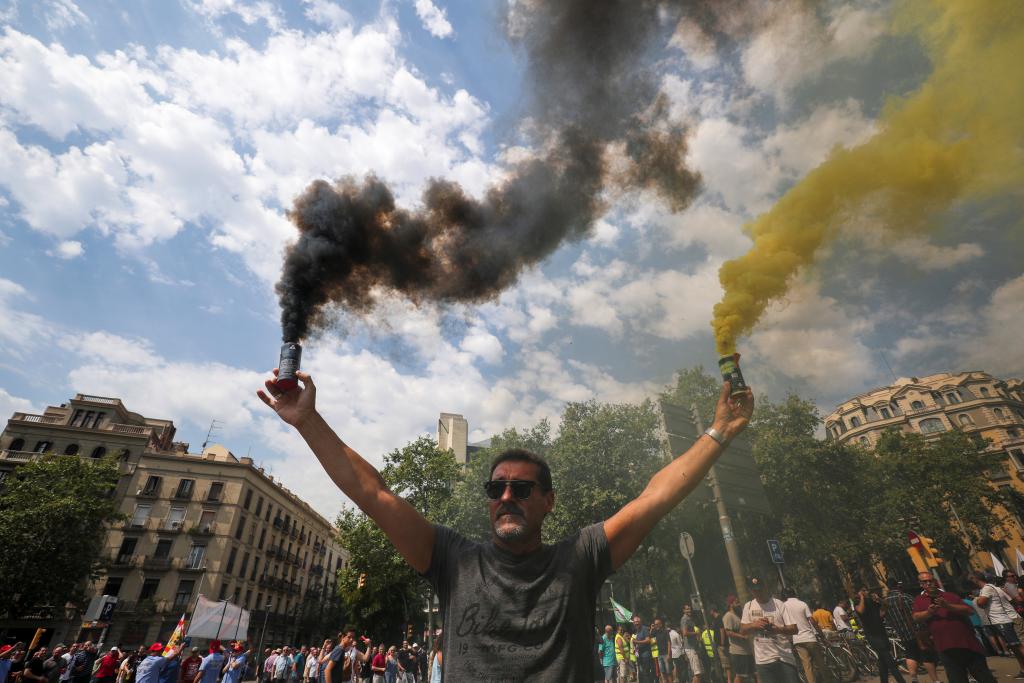 A taxi driver holds up smoke bombs during a strike against what they say is unfair competition from ride-hailing and car-sharing